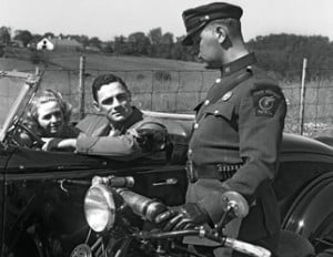 1930s Couple In Convertible Coupe Stopped By Motorcycle Cop Checking License Of Driver