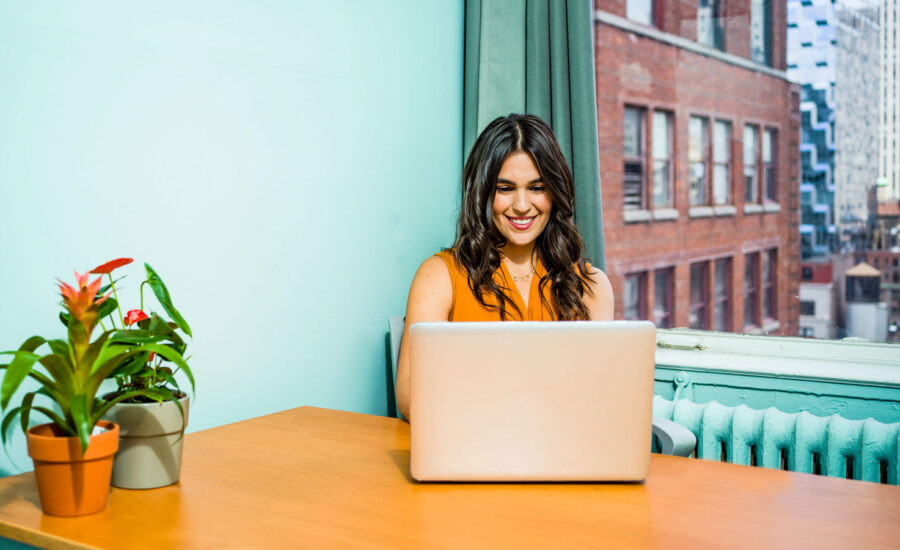 A woman at her desk looking at the location of her investments on her computer