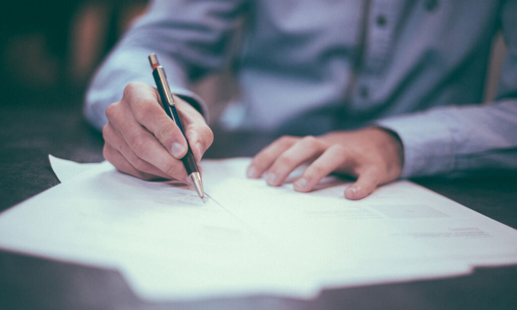 man signing a contract