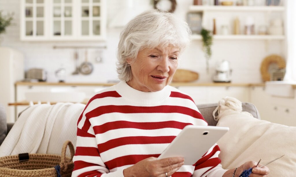 A senior woman checks her mortgage insurance policy on a tablet