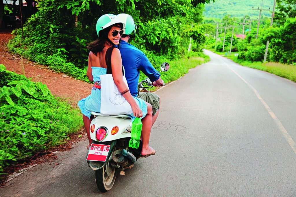 Couple riding scooter in remote area