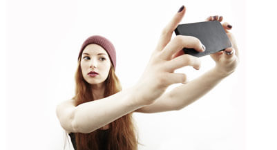 Studio portrait of young woman making selfie on smartphone (JPM/Image Source/Getty images)