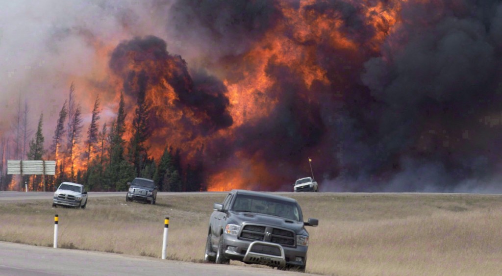 A wild fire rips through the forest 16 kilometres south of Fort McMurray, Alta., on highway 63 on May 7, 2016. (THE CANADIAN PRESS/Jonathan Hayward)