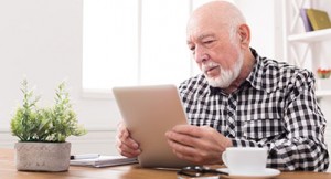 guaranteed income supplement - elderly man looking at digital tablet