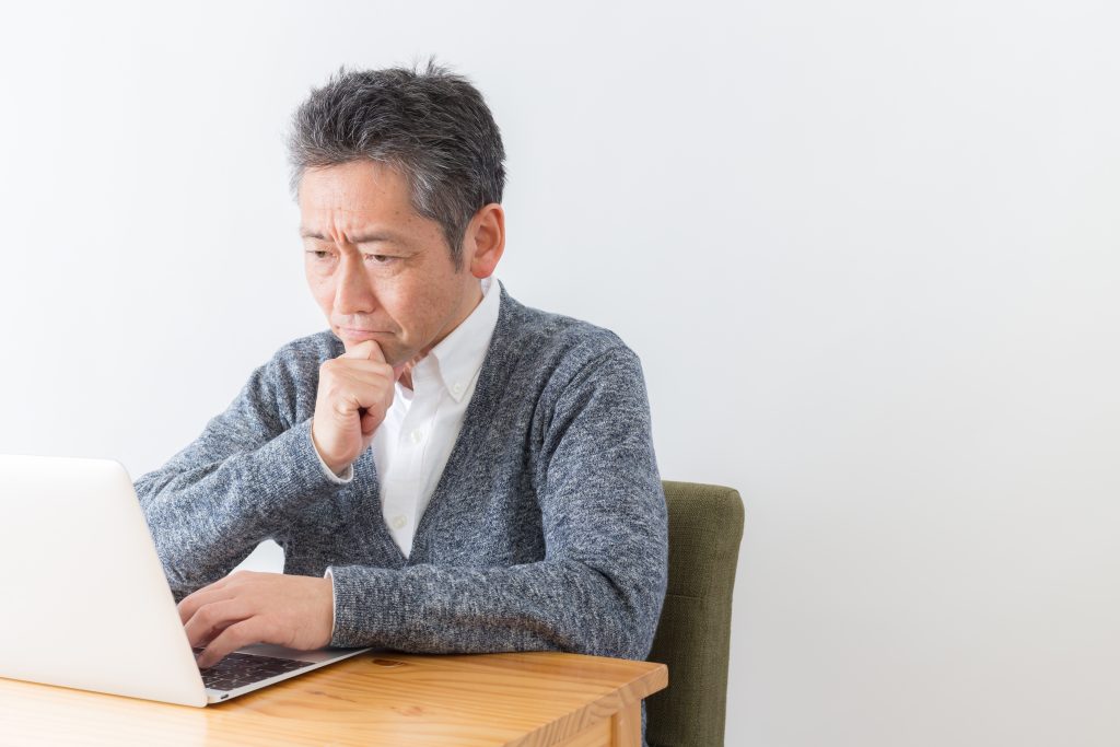 A man is seen staring at a laptop intensely