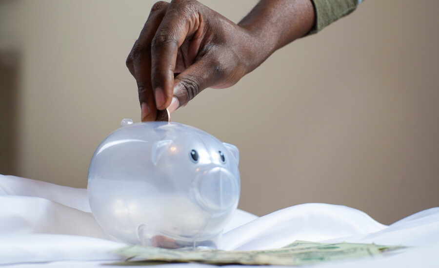 An image of a coin being placed in a piggy bank can be seen