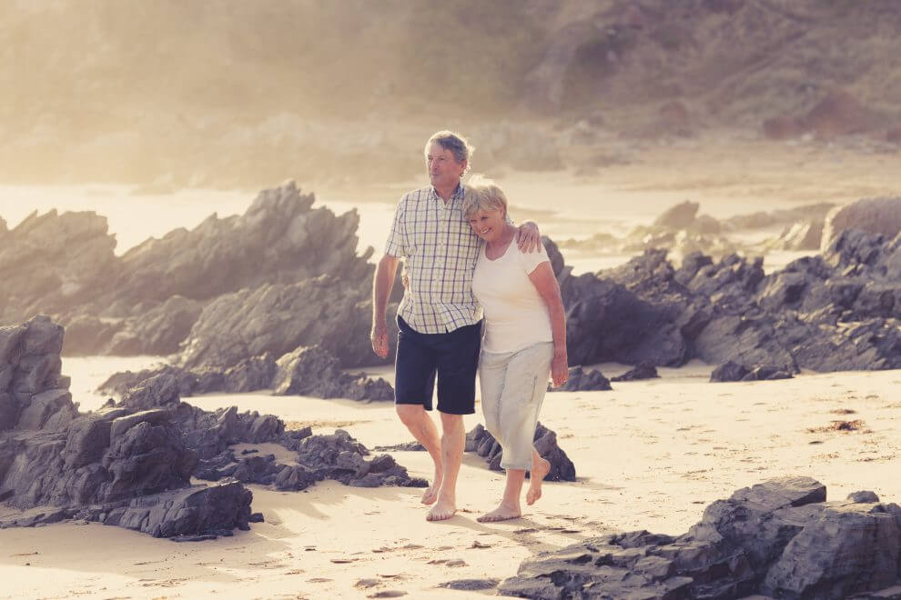 Reducing-taxes-in-retirement-couple-walks-on-beach-Zolo