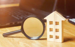 Wooden-house-magnifying-glass-capital-gains-tax-strategies-RKHomeowner