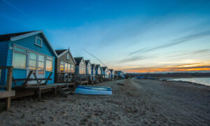 A beach front view of a row of cottages
