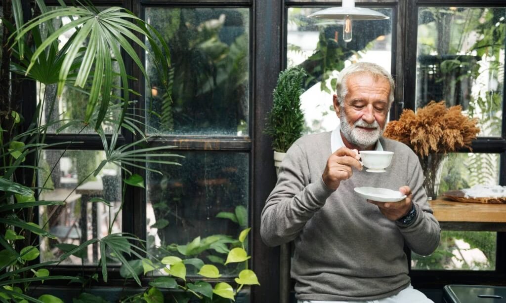A old man is seen drinking from a cup