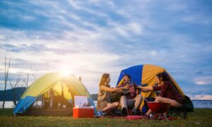 Group of man and woman enjoy camping picnic and barbecue at lake