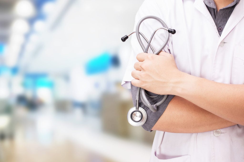 Doctor with a stethoscope in the hands and hospital background