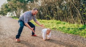 a man watching his child walk for the first time