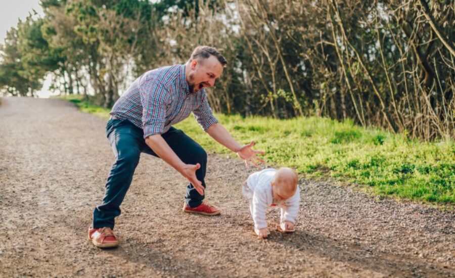 a man watching his child walk for the first time