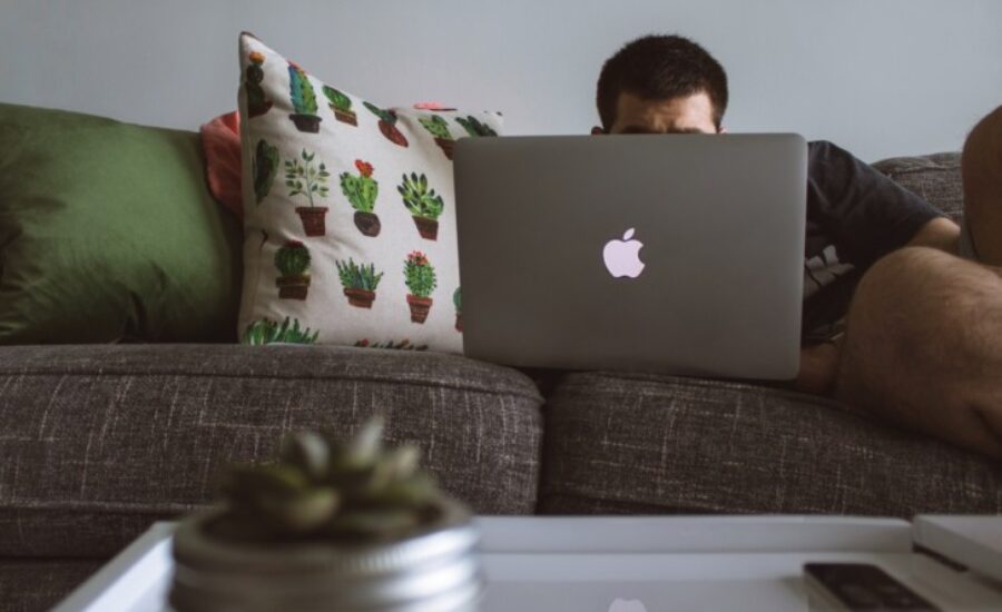 a man on a couch with a laptop