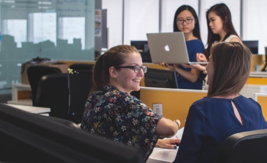 a woman sitting at a desk chatting with friends