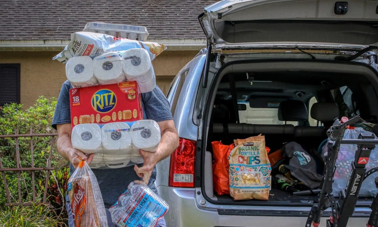 a man loads costco purchases into the trunk of his hatchback