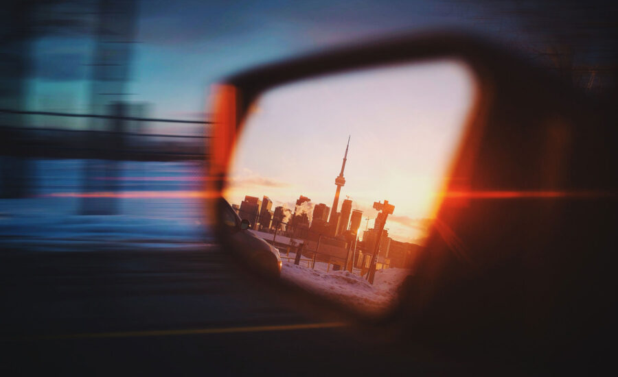 Review mirror showing the city scape of Toronto with the CN Tower at the peak