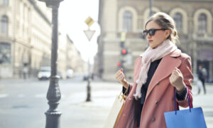 well dressed woman on a street holding shopping bags