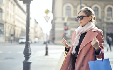 well dressed woman on a street holding shopping bags