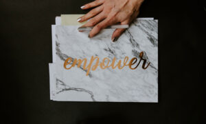 hand on a folder that reads empower, as in these tips will empower you when doing your taxes!