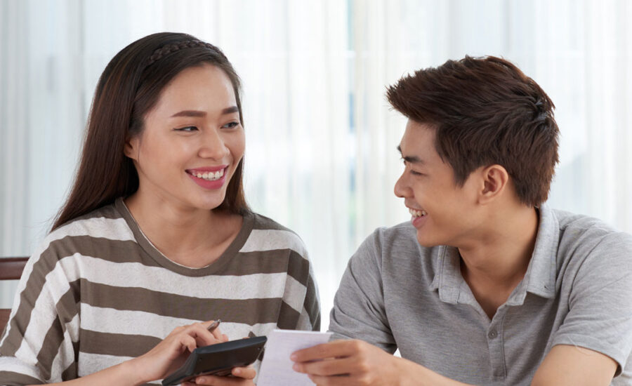 Two people doing their taxes. They're smiling because they're using our tips!