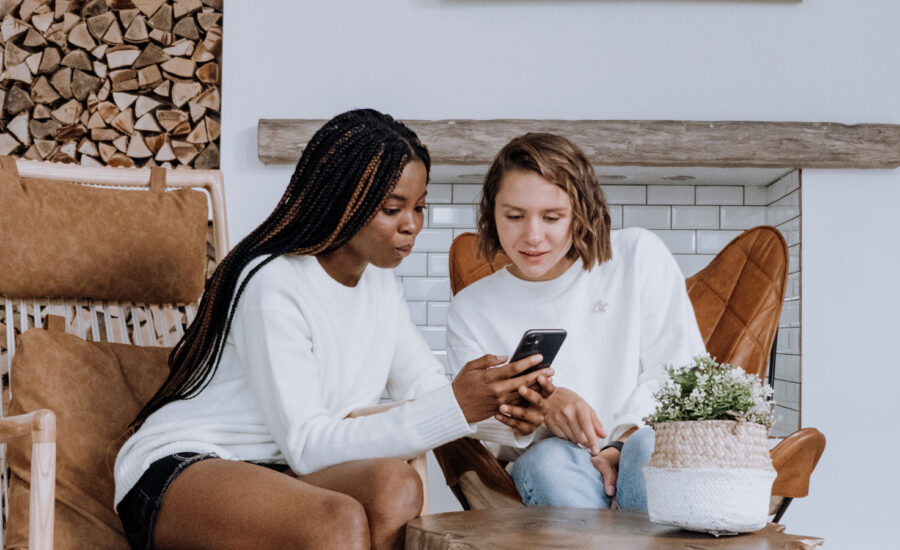 two roommates going over the photos of their belongings on a cell phone