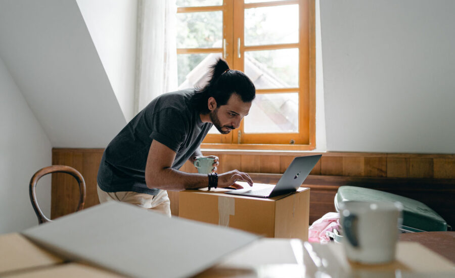 A man at home, scrolling his computer for the best TFSA rates