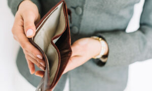 A woman looking inside an empty wallet