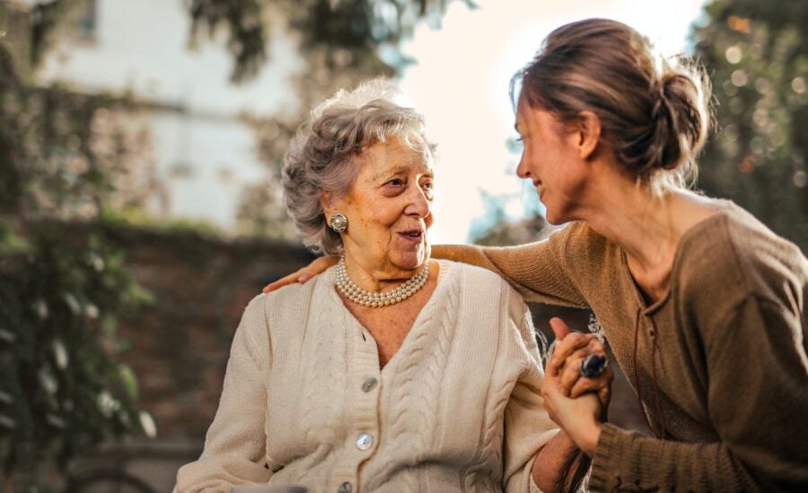 Senior woman sitting with adult daughter in a park