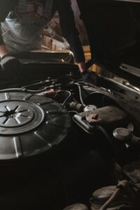 car owner looking under hood at engine