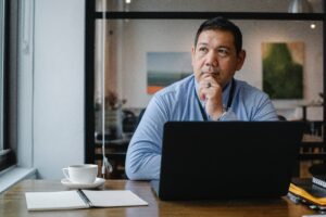 man sitting at laptop looking pensive