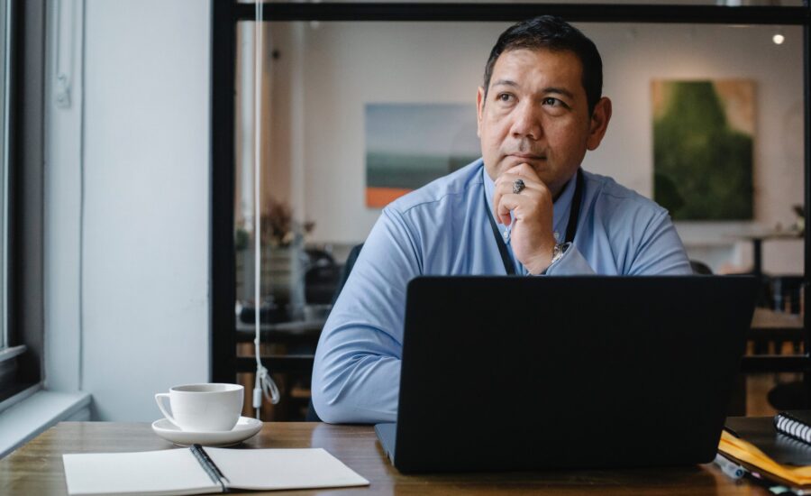 man sitting at laptop looking pensive