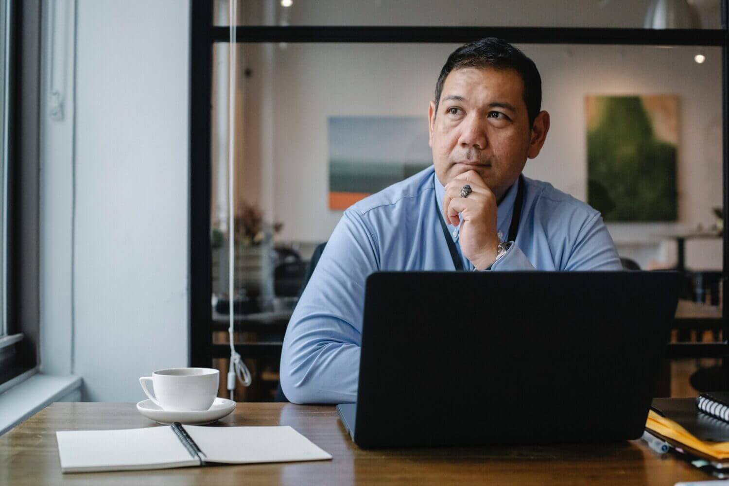 man sitting at laptop looking pensive