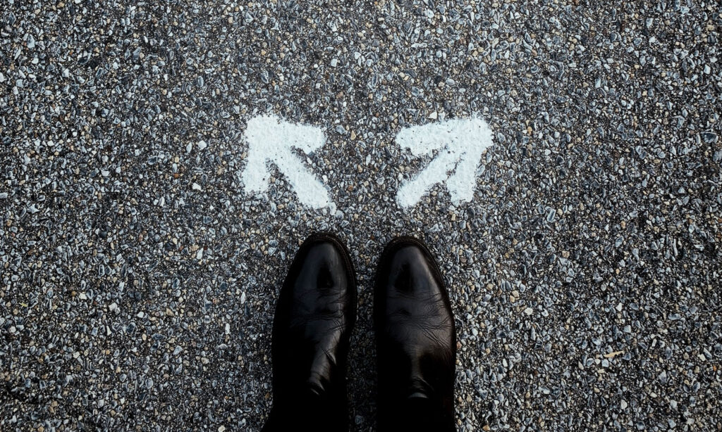 A woman looking down at her feet, trying to figure out which way to go.