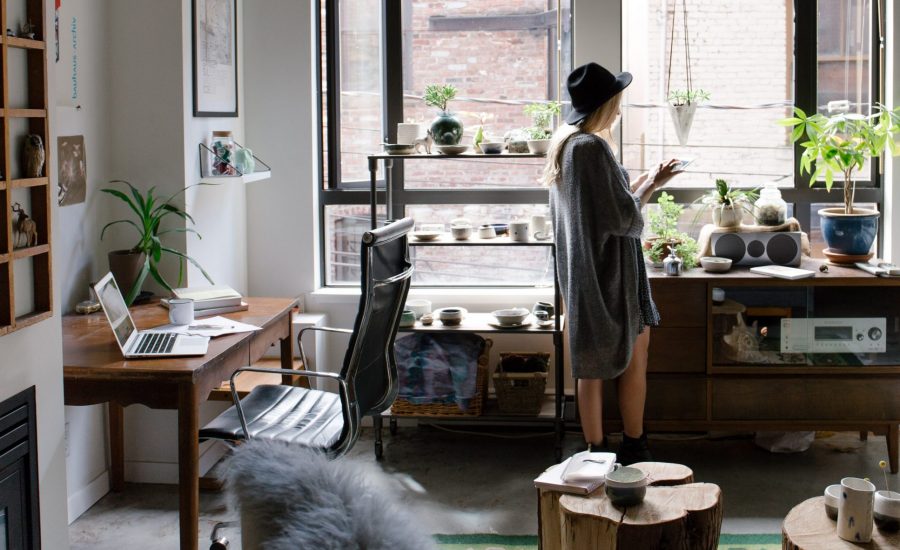 woman standing by window in her home office