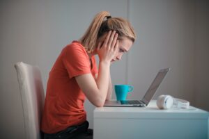 worried woman looking down at laptop computer