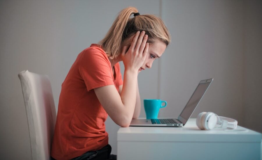 worried woman looking down at laptop computer