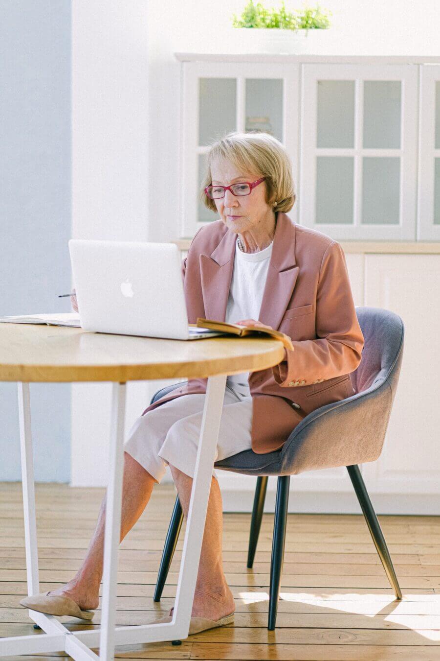 senior woman using laptop computer at table