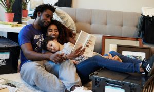 A family just moving into a home, taking a moment together to read a children's book