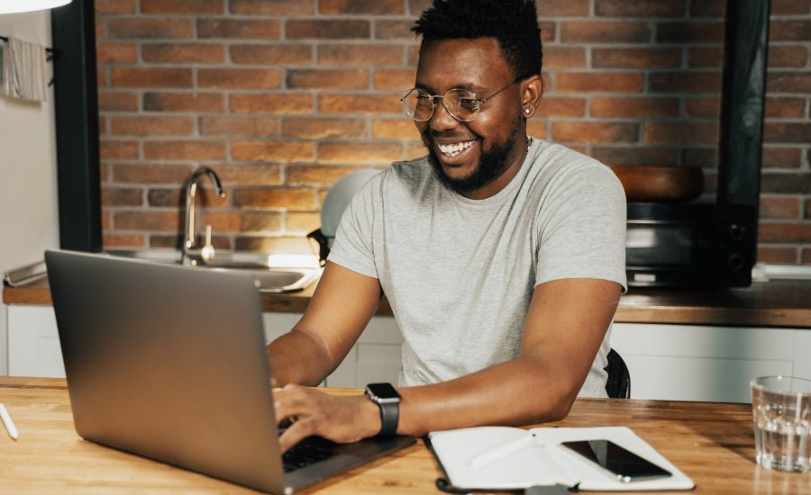 smiling man using laptop computer in his home