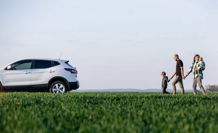 Young family with kids travelling by car, stopped in the field