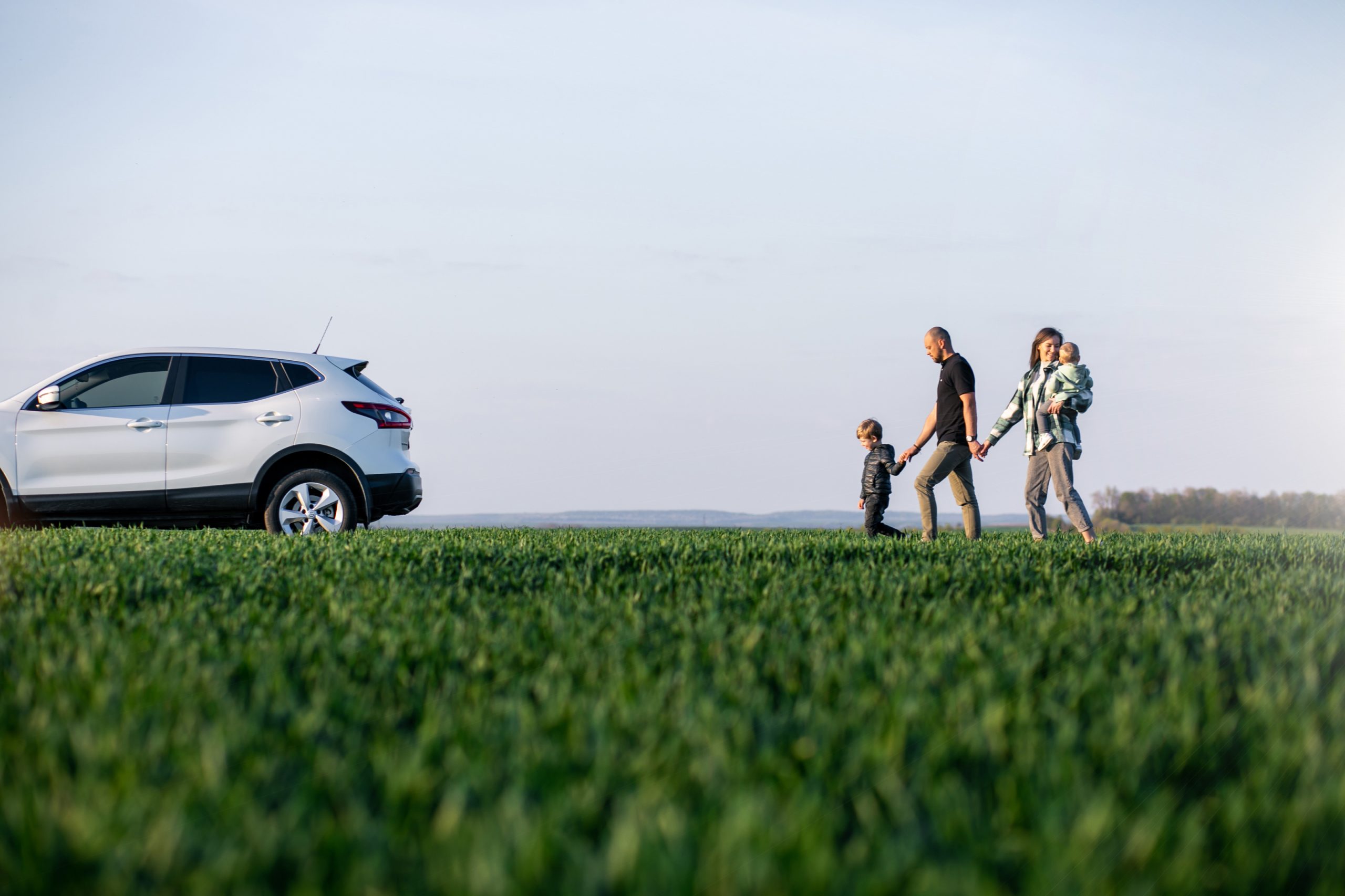 Young family with kids travelling by car, stopped in the field