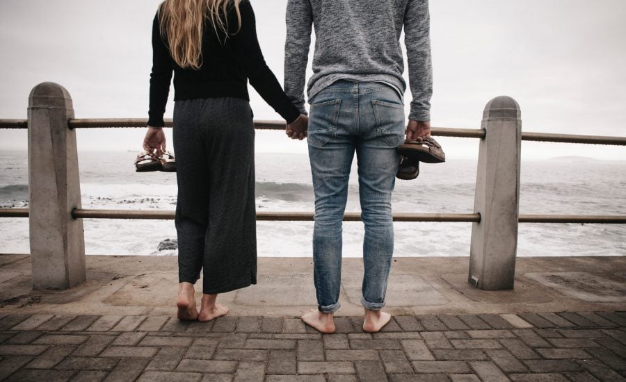 couple holding hands by the waterfront