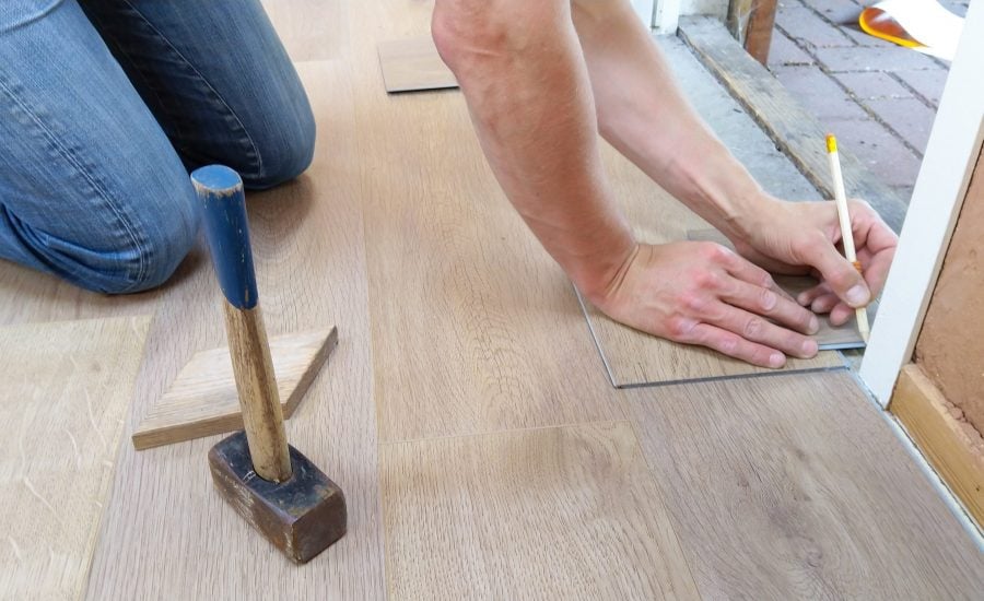 person installing flooring inside a home