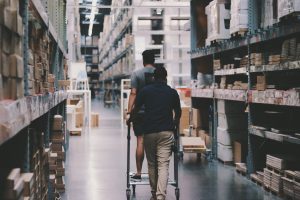 two men with a cart in warehouse