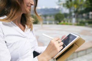 woman signing document using tablet