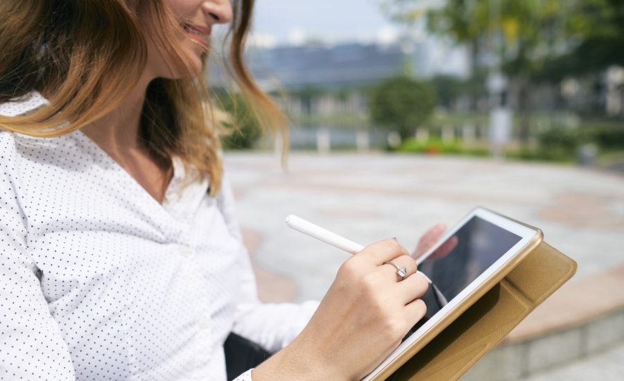 woman signing document using tablet