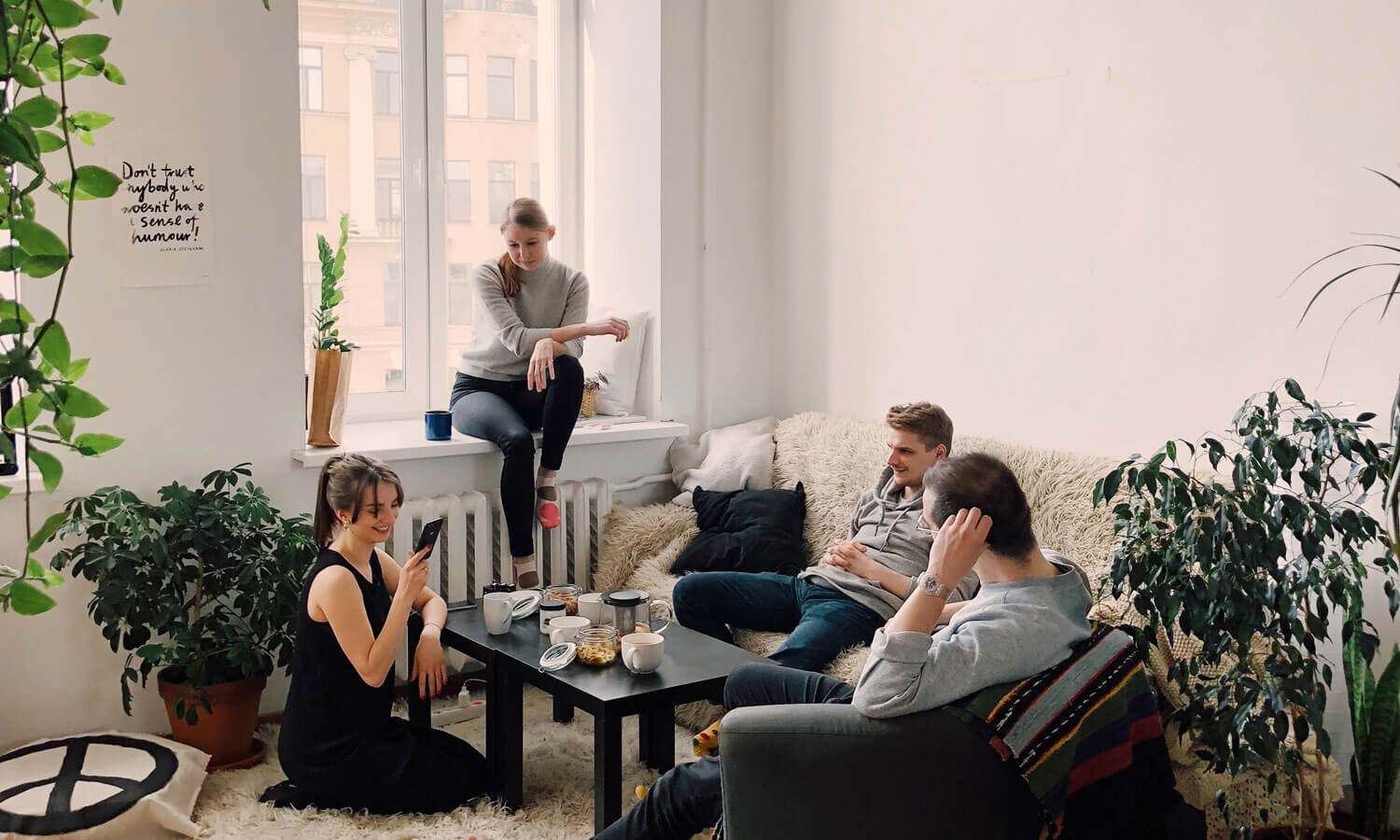 A group of friends are sitting around the living room of an apartment