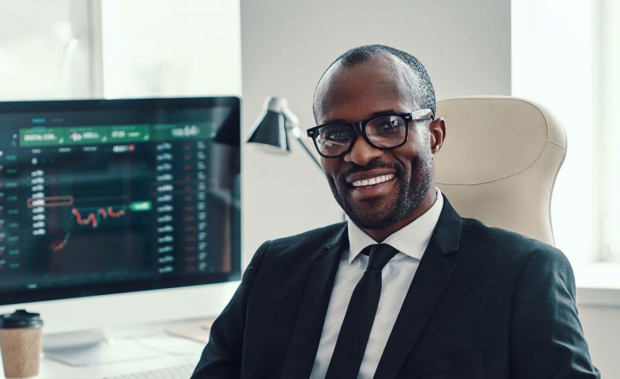 A man sits at his desk smiling